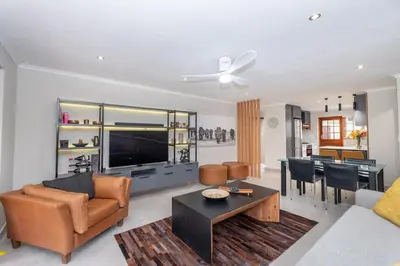 a living room with a couch and a table at Serenity at Cape Bay in Helderberg