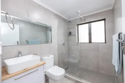 a bathroom with a toilet and a sink and a shower at Serenity at Cape Bay in Helderberg