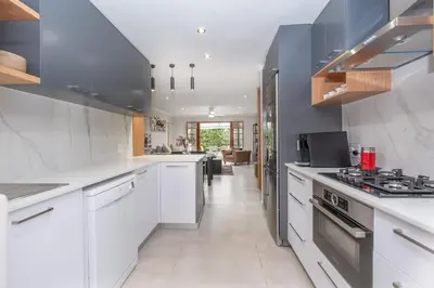 a kitchen with white cabinets and a stove top oven at Serenity at Cape Bay in Helderberg