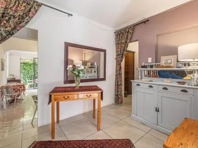 a kitchen with a table with a vase of flowers on it at Absolute Bosch Guest House in Stellenbosch