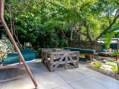 a patio with two benches and a table at Absolute Bosch Guest House in Stellenbosch