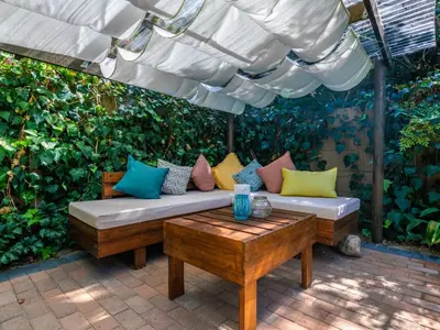 a patio with a couch and a table with pillows at Absolute Bosch Guest House in Stellenbosch