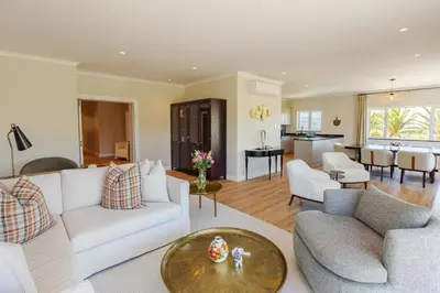 a living room with a white couch and a table at The Helderview Luxury Suites in Somerset West
