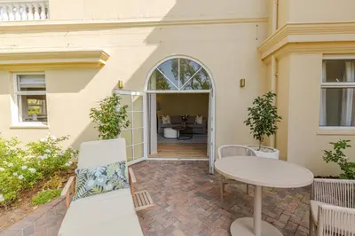 a patio of a house with a table and chairs at The Helderview Luxury Suites in Somerset West