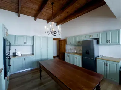 a kitchen with blue cabinets and a wooden table at Vendome Wine Estate in Paarl