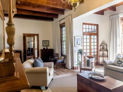 a living room with white furniture and wooden ceilings at Vendome Wine Estate in Paarl