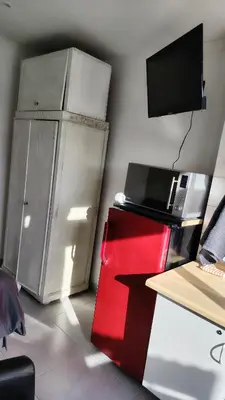 an office with a refrigerator and a desk with a tv at Kenwyn Micro Apartments in Cape Town