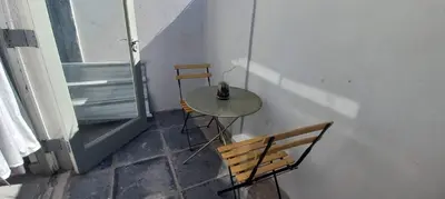 a table and two chairs in a room with a window at Kenwyn Micro Apartments in Cape Town