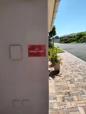 a red sign on the side of a building at Hermanus Beach Club 223 in Hermanus