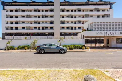 a car parked in a parking lot in front of a building at Lifestyle Accommodation in Cape Town