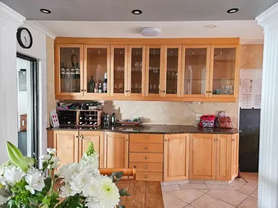 a kitchen with wooden cabinets and a counter top at Indoor Pool Paradise in Stellies in Stellenbosch