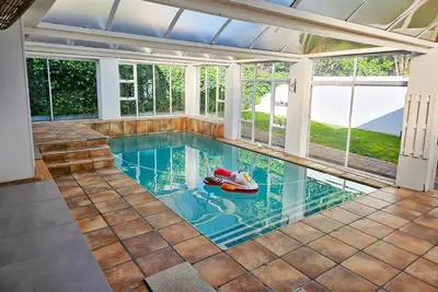 an indoor swimming pool with a room with windows at Indoor Pool Paradise in Stellies in Stellenbosch