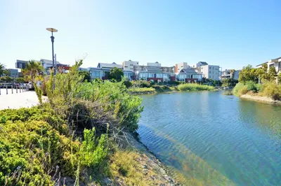 a river with houses and buildings in the background at Quayside 1 Bedroom Apartment in Century City in Cape Town