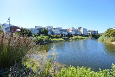 a river in a city with buildings in the background at Quayside 1 Bedroom Apartment in Century City in Cape Town