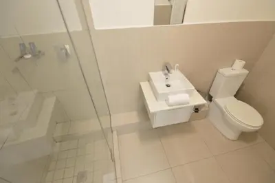 a bathroom with a toilet and a sink and a shower at Quayside 1 Bedroom Apartment in Century City in Cape Town