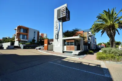 a building with a sign on the side of a street at Quayside 1 Bedroom Apartment in Century City in Cape Town