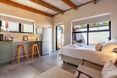 a bedroom with a large bed and a kitchen at Lily's Pad in Oakdale