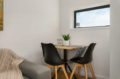 a living room with a table and two chairs at On Park Apartments in Cape Town