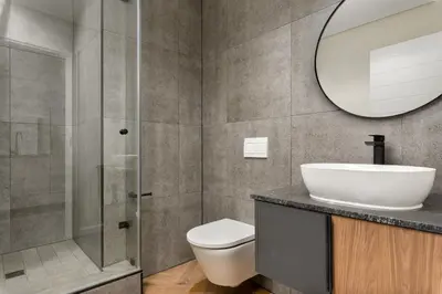 a bathroom with a toilet and a sink and a mirror at On Park Apartments in Cape Town