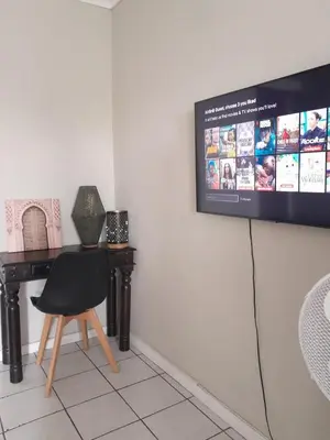 a room with a desk and a tv on the wall at Yannas Guesthouse in Cape Town