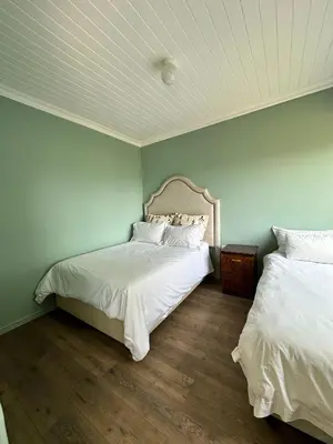 a bedroom with two beds with white sheets at Blossom Cottage, Elgin Grabouw in Grabouw