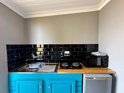 a kitchen with a sink and a microwave at Blossom Cottage, Elgin Grabouw in Grabouw