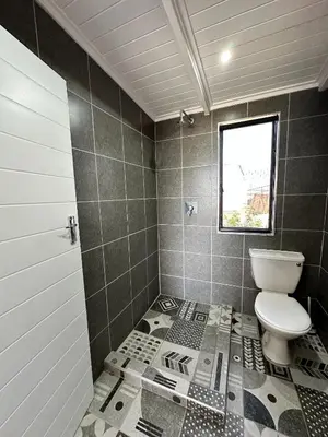a bathroom with a toilet and a window at Blossom Cottage, Elgin Grabouw in Grabouw