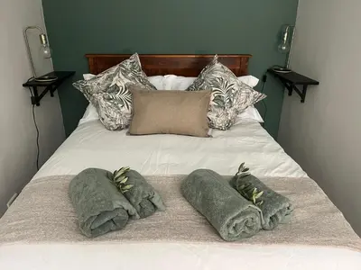 a bed with two pillows and towels on it at Te Môi in Paarl