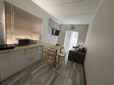 a kitchen with a table and a couch at Te Môi in Paarl