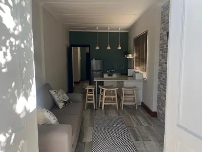 a living room and kitchen with a couch and a table at Te Môi in Paarl