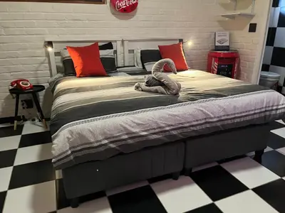 a bedroom with a large bed with a stuffed animal on it at The Cola Cabana in Cape Town