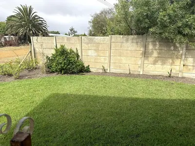 a backyard with a fence and a grass yard at Laid-Back Tortoise in Fisherhaven