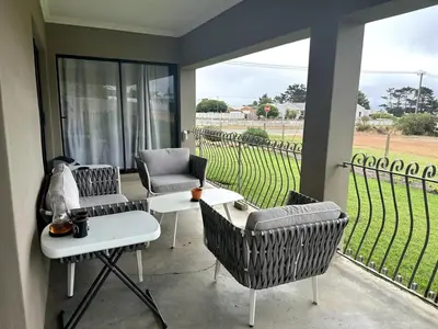a patio with chairs and tables and a view of a field at Laid-Back Tortoise in Fisherhaven