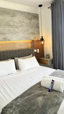 a bedroom with two beds with white pillows at 2 bed Luxury apartment living in Cape Town