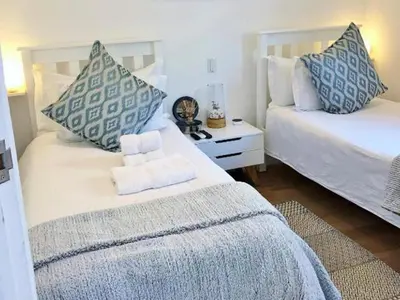 a bedroom with two beds with blue and white pillows at theLAB Franschhoek in Franschhoek