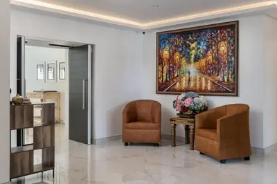 a lobby with two chairs and a painting on the wall at AnnaNella Boutique Hotel in Durbanville