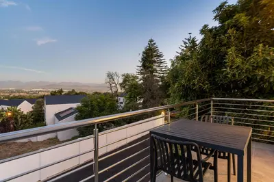 a black table on the balcony of a house at AnnaNella Boutique Hotel in Durbanville