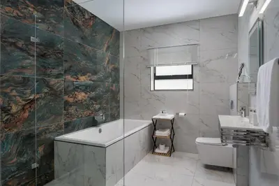 a bathroom with a tub and a toilet and a sink at AnnaNella Boutique Hotel in Durbanville