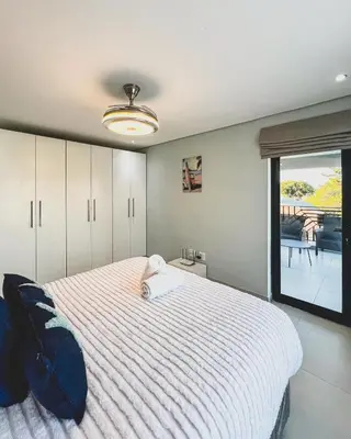 a bedroom with a large bed and a window at Goodness Century Apartment in Cape Town