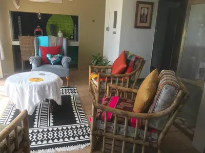 a living room with two chairs and a table and a tableablish at 120 steps to the beach in Pringle Bay