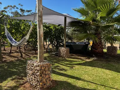 a hammock and a table and chairs under an umbrella at Hephzibah Inn Signature Farm Cottage in Hermon