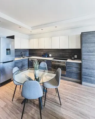a kitchen with a glass table and four chairs at Shalom on Matrix by Dajosha in Cape Town