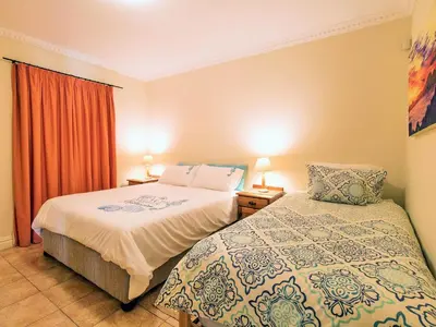 a hotel room with two beds and a window at Goldwater 7 in Gordonʼs Bay