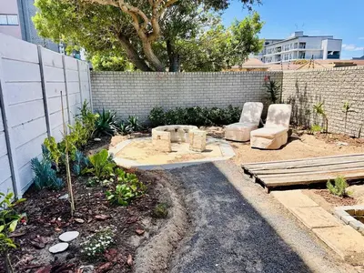 a garden with two chairs and a wooden bench at Dolce in Cape Town