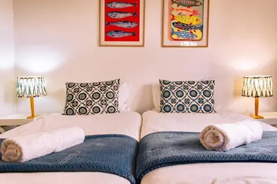 a living room with two beds and two lamps at Mountainside Beach House in Hermanus