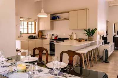 a kitchen with a table with wine glasses on it at Mountainside Beach House in Hermanus