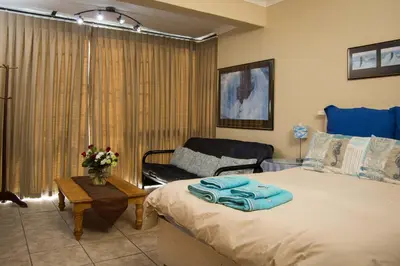 a bedroom with a large bed and a couch at 9 Lantra in Strand