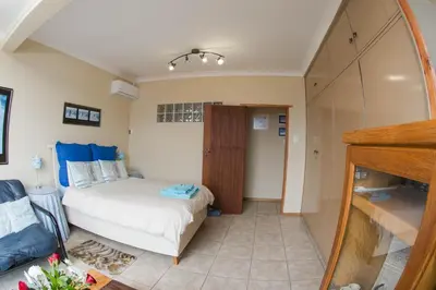 a small bedroom with a bed and a mirror at 9 Lantra in Strand