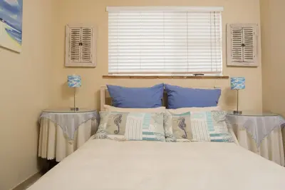 a bedroom with a large bed with blue pillows at 9 Lantra in Strand