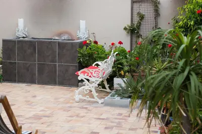 a red and white bench in a courtyard with flowers at 9 Lantra in Strand